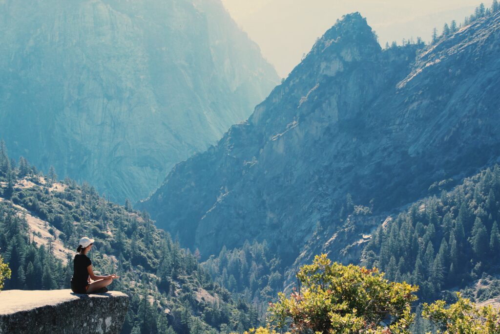 Millionaire Mindset - image of someone meditating on a cliff 