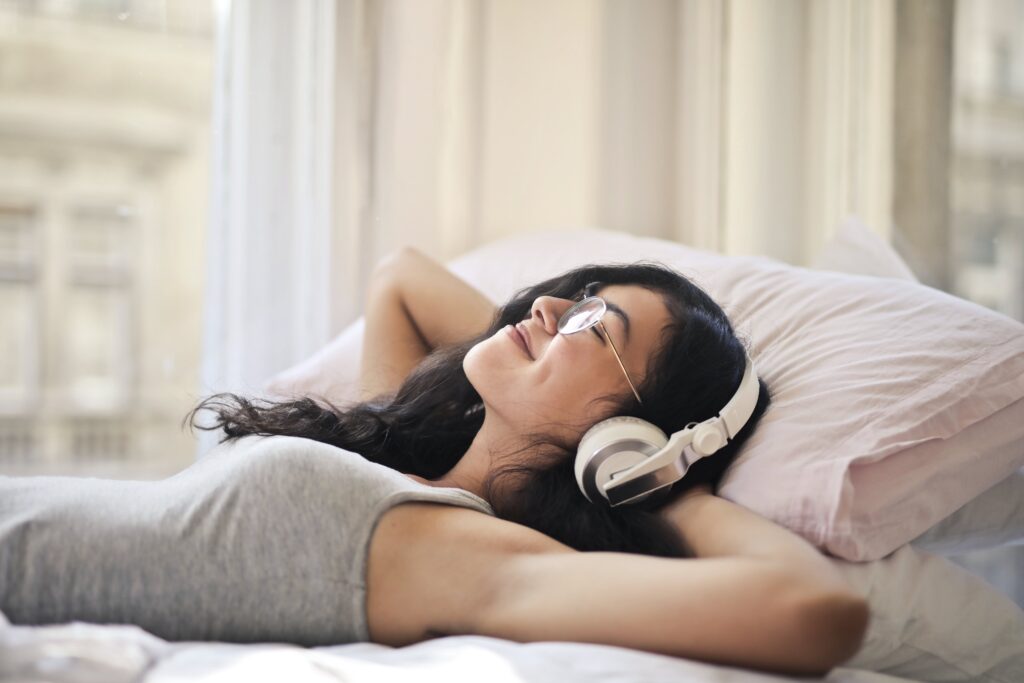 Meditations for abundance - image of woman resting and listening to headphones
